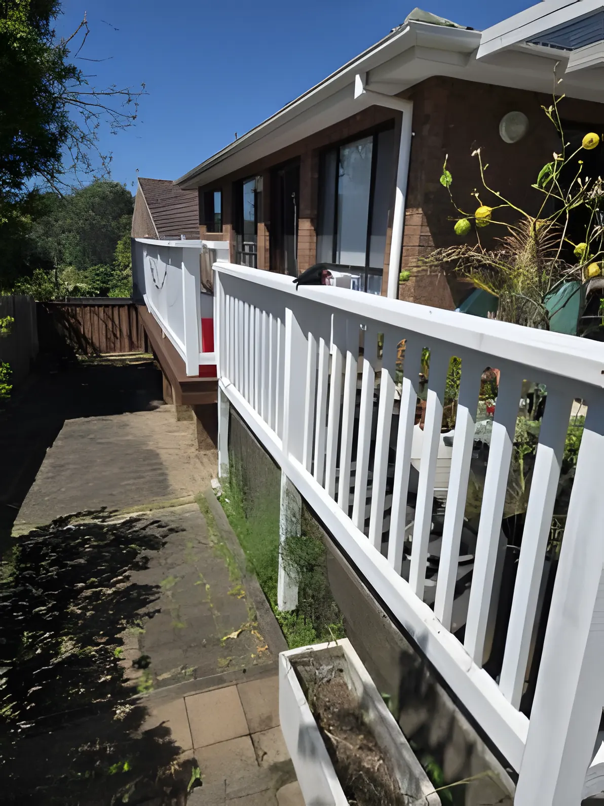 A freshly painted white timber balustrade on a brick house