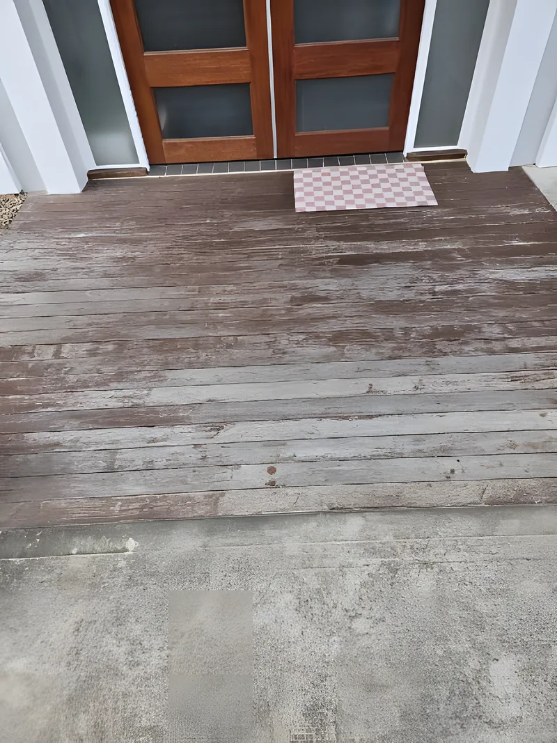 A weathered grey timber deck, silvered and dried out before restoration