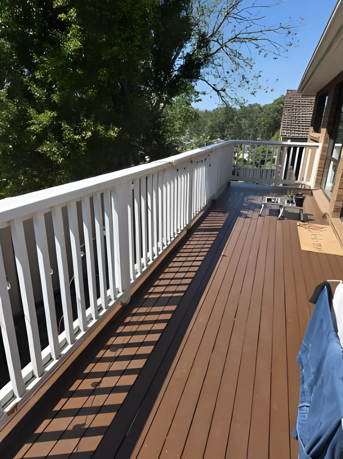 A timber deck freshly oiled, with the balustrade painted white