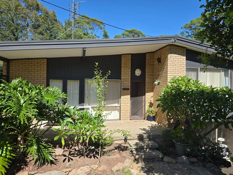 A brick and weatherboard house with fascia and cladding newly painted in Dulux Monument