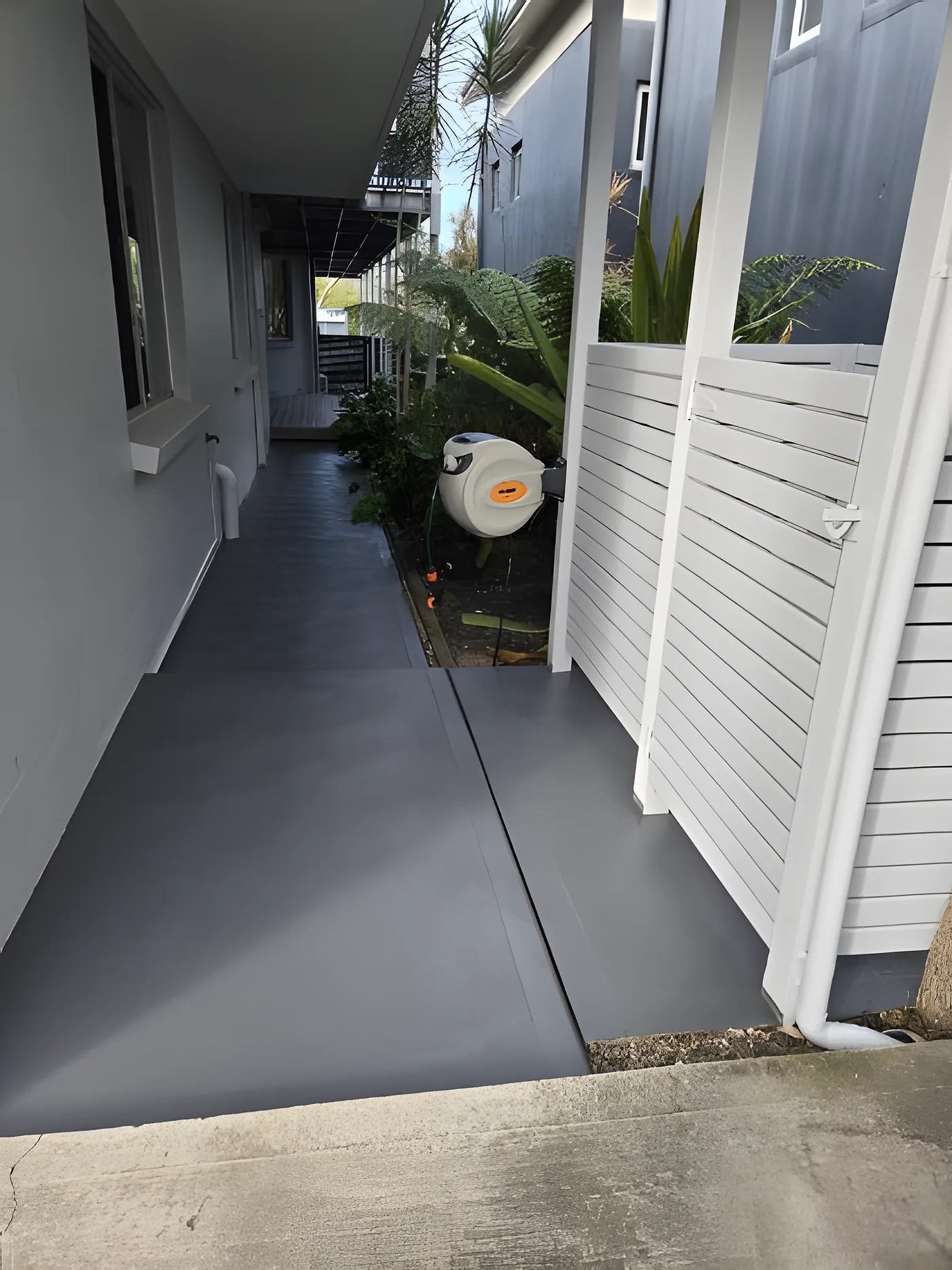 A charcoal coated concrete driveway path