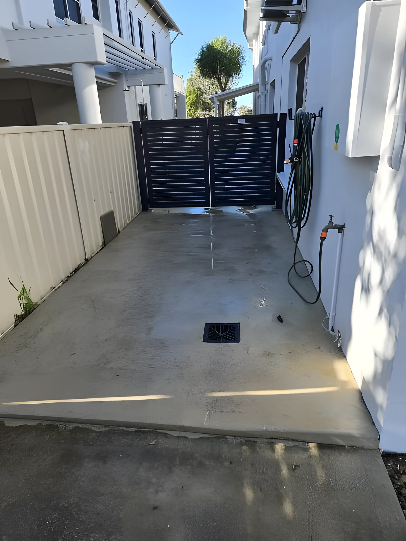 A stained concrete path before pressure washing